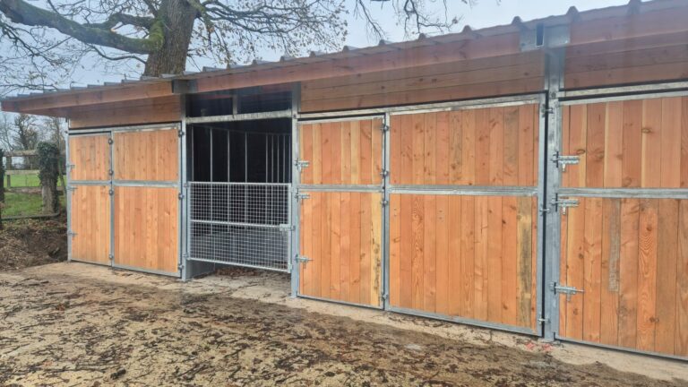 Row of Stable Boxes with Central Circular Hay Rack, Ideal for Feeding a Complete Round Bale